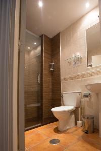 a bathroom with a toilet and a glass shower at Hotel La Encomienda in Moraleja