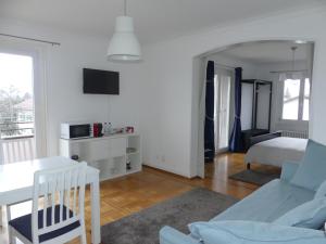 a white living room with a bed and a table at Au Bonheur des Iris in Rolle