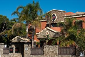 un edificio con palmeras delante en Hotel Coral Playa en Chiclana de la Frontera