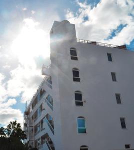 a tall white building with the sky in the background at Apartamentos Calma in Playa del Ingles