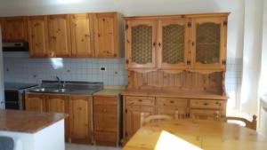 cocina con armarios de madera y mesa de madera en Fattoria Zitumasse, en Crecchio