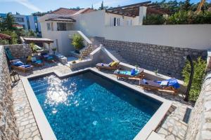 a swimming pool with chairs and a house at Villa Blue Diamond in Mlini