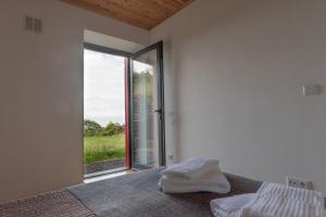 ein Schlafzimmer mit einem Bett und einem großen Fenster in der Unterkunft Casa do Cedro do Mato in Terra Alta