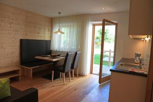 cocina y comedor con mesa y sillas en Appartements Mutschlechner en Valdaora