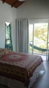um quarto com uma cama e uma grande janela em Monsal Apartamento em Florianópolis