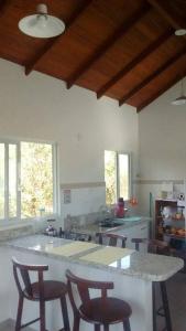 uma cozinha com um balcão e algumas cadeiras em Monsal Apartamento em Florianópolis