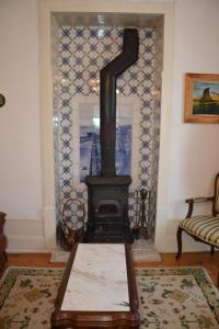 a fireplace in a living room with a couch and a table at Casa da Ponte do Arrocho in Loriga