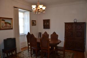 a dining room with a table and chairs and a television at Casa da Ponte do Arrocho in Loriga