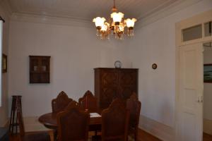 ein Esszimmer mit einem Kronleuchter, einem Tisch und Stühlen in der Unterkunft Casa da Ponte do Arrocho in Loriga