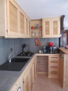 uma cozinha com armários de madeira e um lavatório em Maison Des Abeilles Vda Gressan n 0028 em Gressan