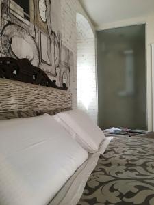 a bedroom with a white bed with a brick wall at Suite Romantica Fuga in Roncone