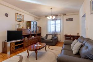 a living room with a couch and a tv at Vacation home Duilo in Donji Zemunik