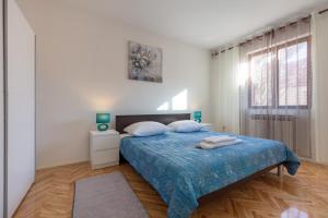 a bedroom with a bed with blue sheets and a window at Vacation home Duilo in Donji Zemunik +25 photos