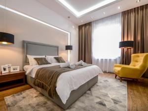 um quarto com uma cama grande e uma cadeira amarela em Main Square Residence em Belgrado