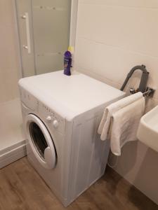 una lavatrice in un bagno con specchio di Logie Rotem a Dilsen-Stokkem