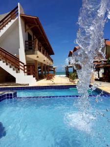 a water fountain in front of a house at Pousada e Restaurante Altas Horas Beach in Itapipoca