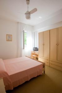 a bedroom with a bed and a dresser and a window at Hotel Santa Lucia in Guardia Piemontese Terme