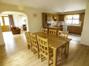 uma cozinha e sala de jantar com uma mesa de madeira e cadeiras em Maison de Kilbride Finney Clonbur Mayo em Clonbur