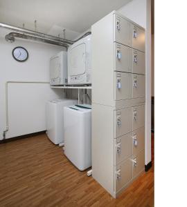 a laundry room with washer and dryer machines and cabinets at Nozawaonsen Guest House Miyazawa in Nozawa Onsen