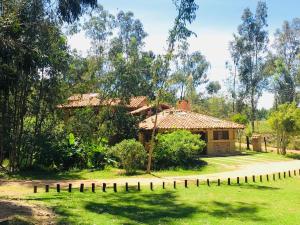 uma casa com uma cerca em frente a um quintal em Clavellino House Campestre-Villa de Leyva-WIFI em Villa de Leyva