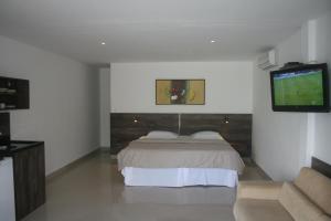 um quarto com uma cama e uma televisão de ecrã plano em Villa Imperador em João Pessoa