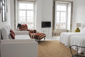 a white room with two beds and a tv at Mo House in Porto