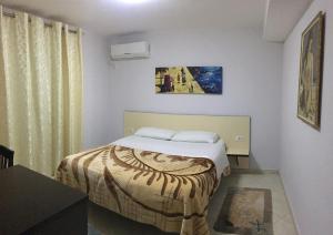 - une chambre avec un lit et une peinture murale dans l'établissement Hotel M&S, à Tirana
