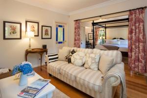 sala de estar con sofá y cama en Fern Falls Cottages - Garden Cottage en Mount Dandenong