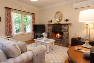 uma sala de estar com lareira e sofá em Fern Falls Cottages - Garden Cottage em Mount Dandenong
