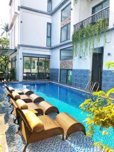basen z krzesłami obok budynku w obiekcie Ivy Villa w Hoi An