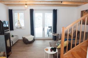 a living room with a staircase and a couch at Ferienhäuser Glück Auf, Sauna, Hottubs in Arnoldstein