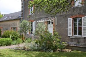 uma casa antiga com um jardim em frente em Maison St Mayeul em Bouère