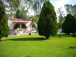 a group of trees in a park with a building at Villas Premier in Tequisquiapan +16 photos
