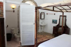 a bedroom with a bed and a bathroom with a toilet at hotel florita in Jacmel +128 photos