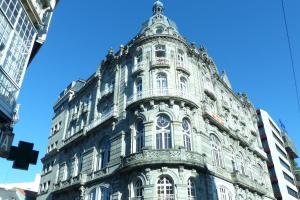 um edifício alto com uma torre em cima em Edificio El Moderno, Vigo 1.902 em Vigo