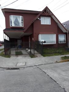 a red house with a fence in front of it at Depto. Altos de Tenglo in Puerto Montt