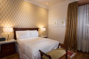 um quarto de hotel com uma cama e uma cadeira em Hotel Boutique Santa Lucia em Cuenca