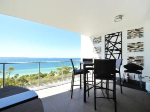 a room with a table and chairs and a view of the ocean at Nautilus by Rockingham Apartments in Rockingham