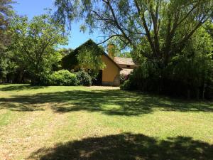 a house with a large yard with a tree at Los 12 Robles in Batán