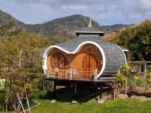 a round building with a roof on a field at Kiri Pura Resort in Khao Kho