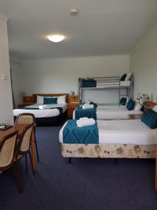 
a bedroom with a bed and a dresser at The Q Motel Rockhampton in Rockhampton

