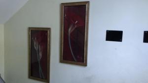 tres pinturas de flores en una pared en Bhammar's Inn - A Pure Veg en Calcuta