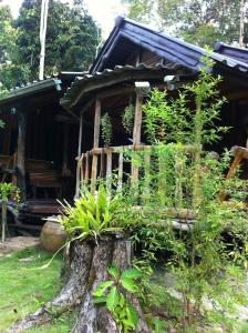 uma casa com um toco de árvore em frente em Koh Kood Little Hut em Ko Kood