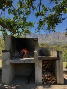 a stone pizza oven with a fire in it at Fisaasbos in Tulbagh