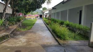 an empty sidewalk next to a building with plants at Jo Homestay in Selong Belanak