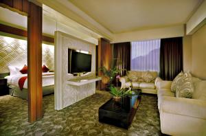 a living room with a couch and a television at Atria Hotel Magelang in Magelang