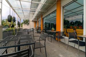 an outdoor patio with tables and chairs and windows at RedDoorz near Exit Toll Bogor in Bogor