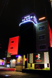 a building with a sign on top of it at night at Hotel TiAMO (Love Hotel) in Kitakyushu