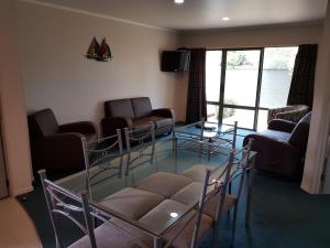 uma sala de estar com cadeiras e uma mesa de vidro em Portmans Motor Lodge em Hastings