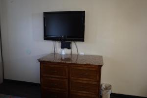 a flat screen tv sitting on top of a dresser at Econo Lodge San Antonio Northeast I-35 in San Antonio